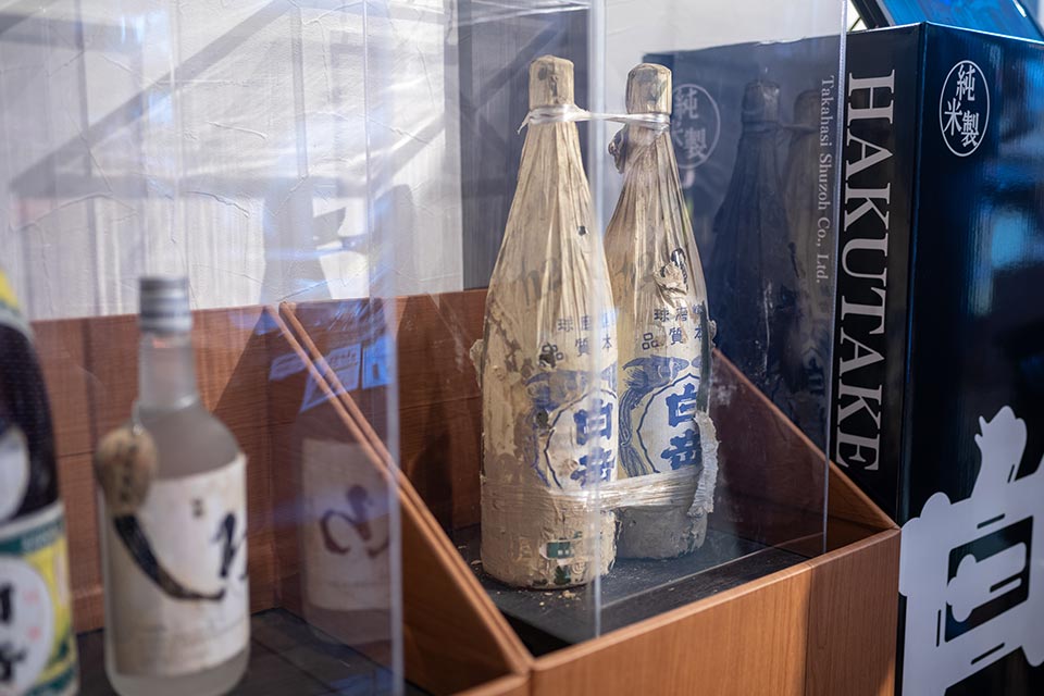 「令和2年7月豪雨」では、高橋酒造の商品倉庫も浸水。浸水した住宅の片付けの際に見つかった45年前の商品を譲り受け、水害を乗り越えた希望の象徴として展示しています