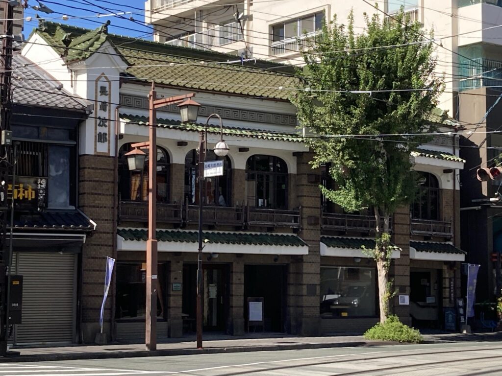 瓦葺や窓の形、タイルなどで歴史を感じる長崎次郎喫茶室の建物外観の写真。