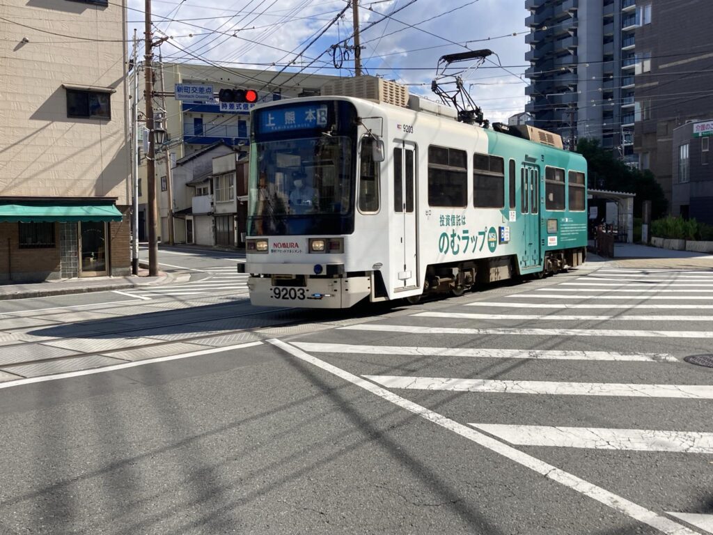長崎次郎喫茶室の目の前の交差点を走る熊本市電の車両