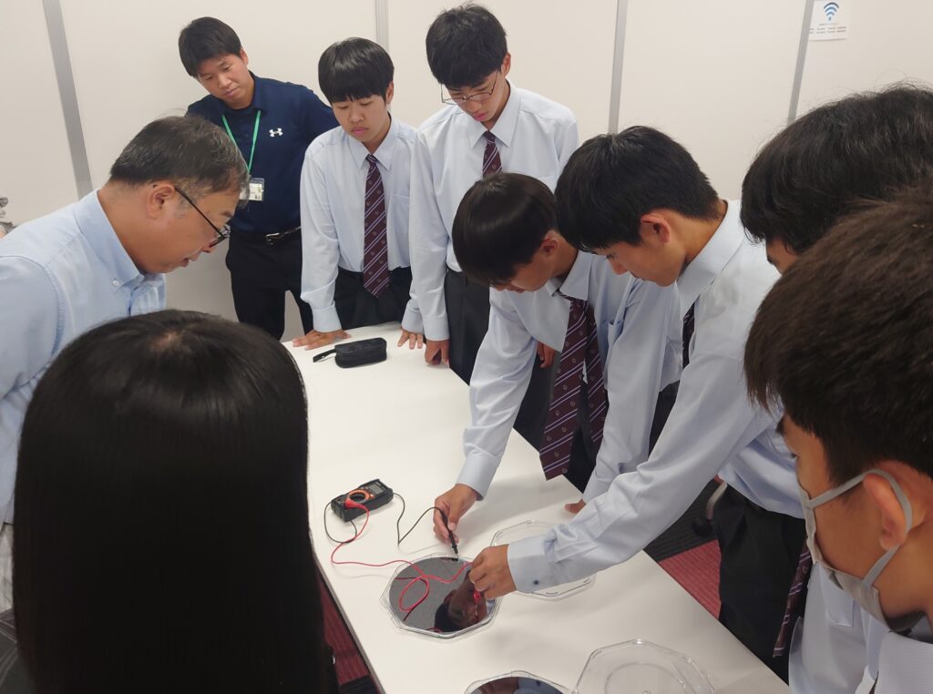 アスカインデックスの社員が見守る中、機器を使った半導体の授業に取り組む水俣高校の生徒たち