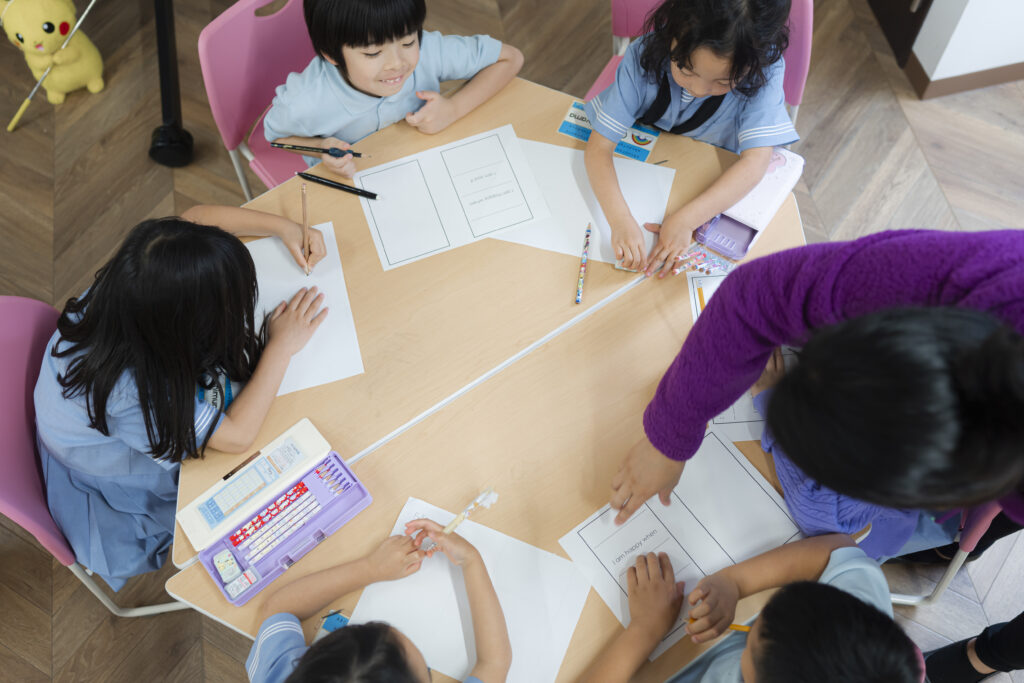 六角形の机で授業を受ける生徒たちを上から移した写真