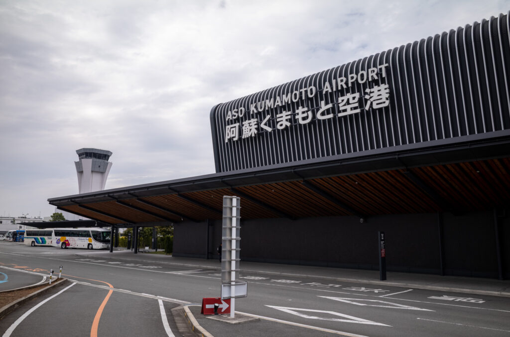 阿蘇くまもと空港の外観。黒地に白く細い縦線が入った壁に空港の名前が記されている